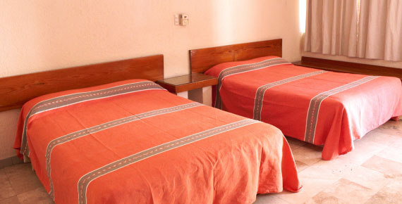 Habitación doble del Hotel Avenida Ixmiquilpan con cama full-size, decoración rústica y amenidades modernas en Hidalgo
