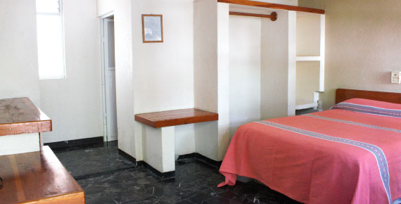 Habitación sencilla del Hotel Avenida Ixmiquilpan con cama full-size, decoración rústica y amenidades modernas en Hidalgo